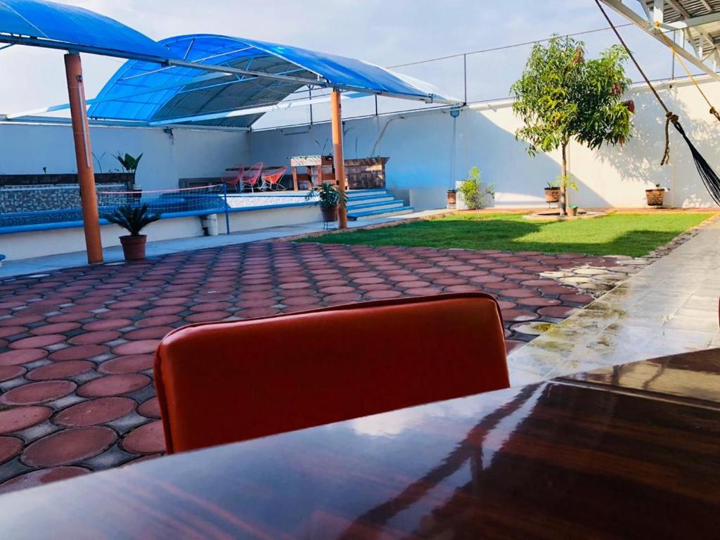 einen roten Stuhl an einem Tisch mit blauen Sonnenschirmen in der Unterkunft Casa el paraíso in Oaxtepec