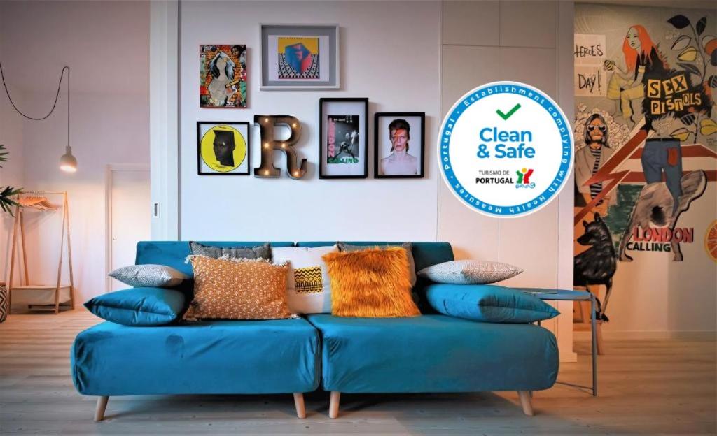 eine blaue Couch in einem Zimmer mit Schild in der Unterkunft Art District - POP & ROCK Apartments in Porto