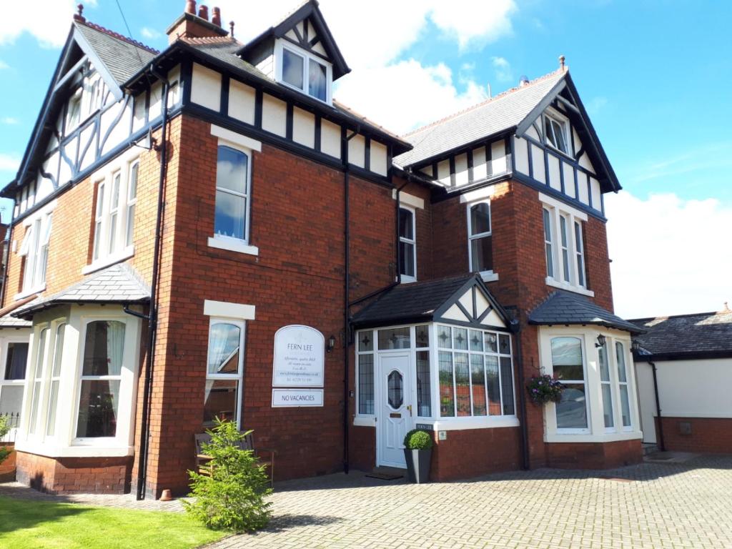 a large brick building with a sign on it at Fern Lee Guest House in Carlisle