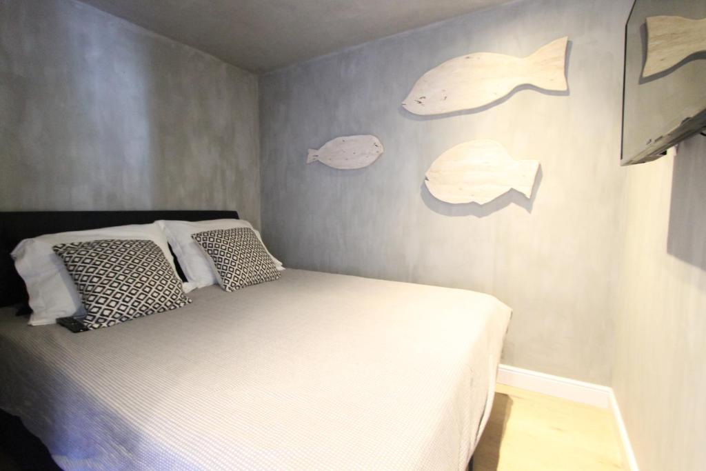 - une chambre avec un lit et un mur avec des étiquettes de poisson dans l'établissement Lily’s Place, à Knokke