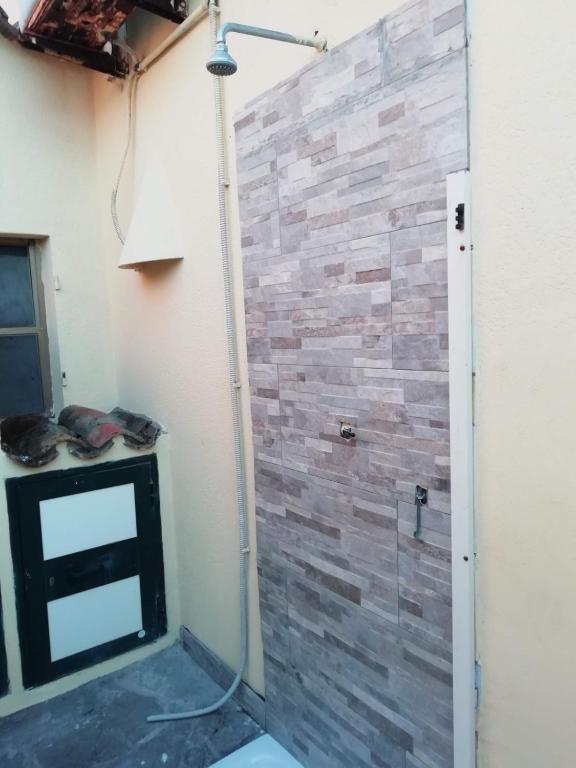 prysznic z kamienną ścianą w pokoju w obiekcie Villetta Sara w mieście Torre dei Corsari