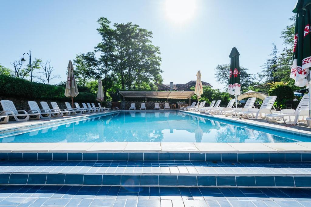 a large swimming pool with chairs at ATOS Srebrno jezero - Villa and Restaurant in Veliko Gradište