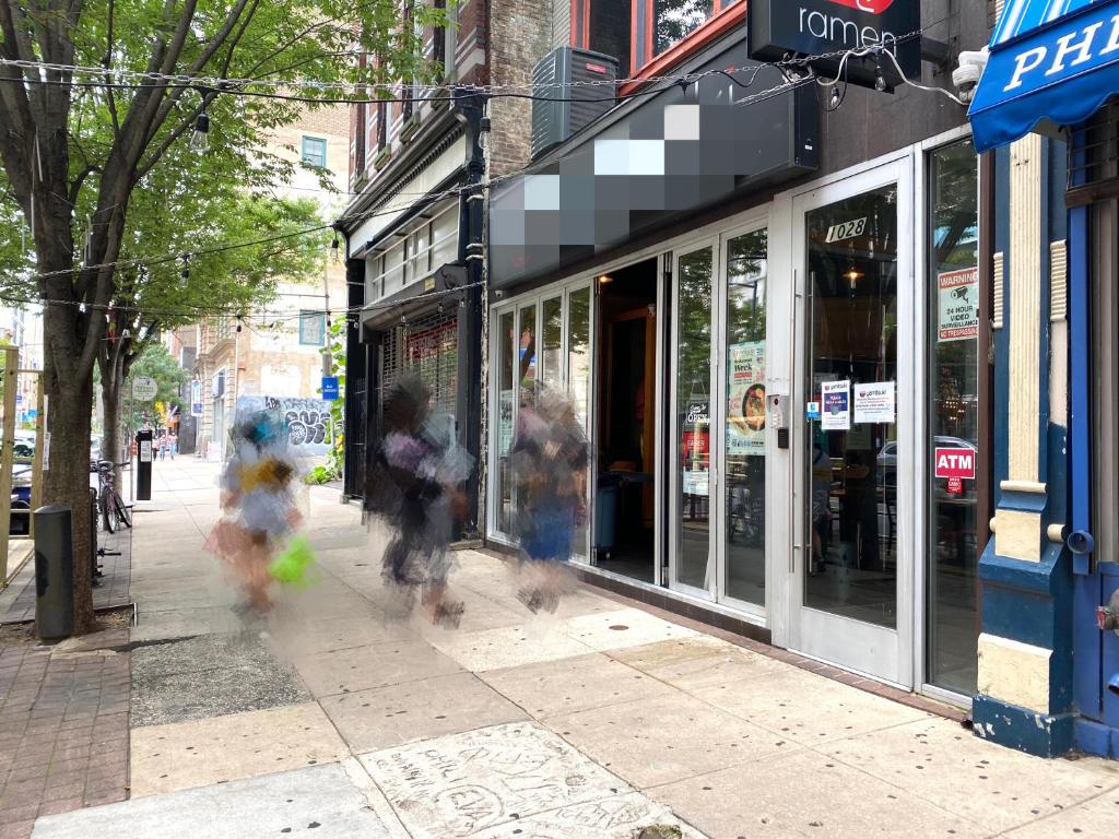 two people are running down a sidewalk in front of a store at Alina & Fanny - Philadelphia Convention Center in Philadelphia