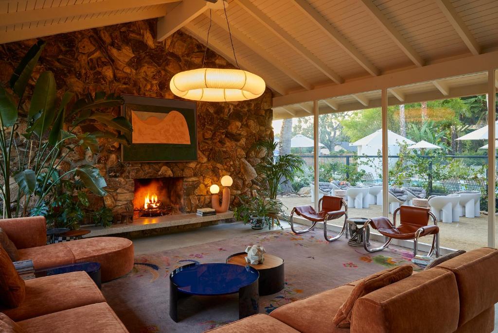 a living room with a stone wall and a fireplace at The Capri Hotel in Ojai