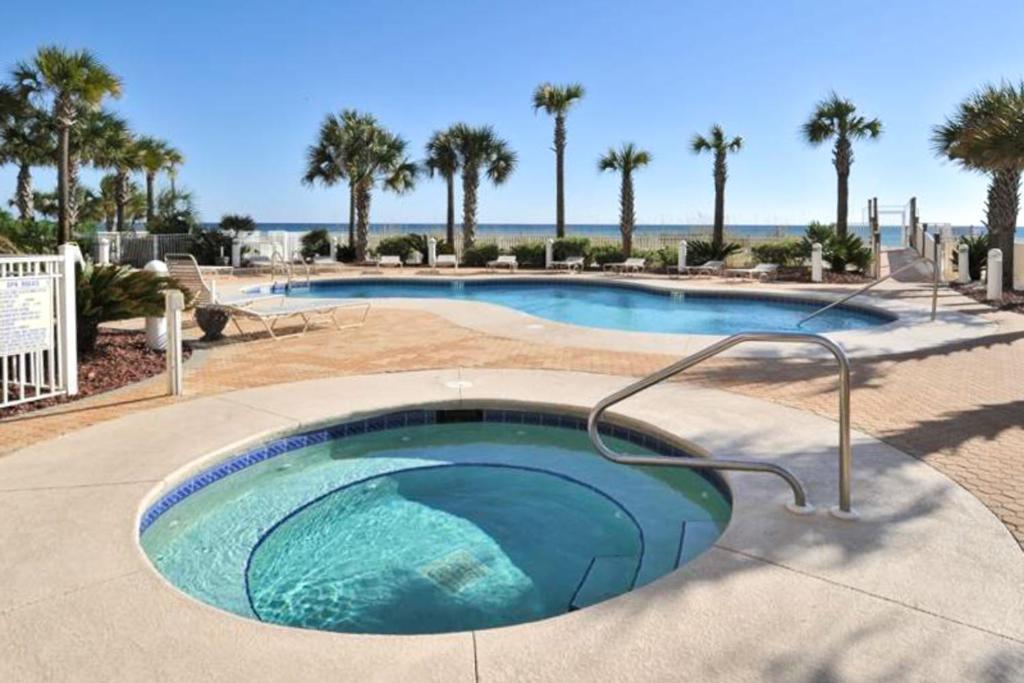 una gran piscina con palmeras en un complejo en Destin Towers, en Destin