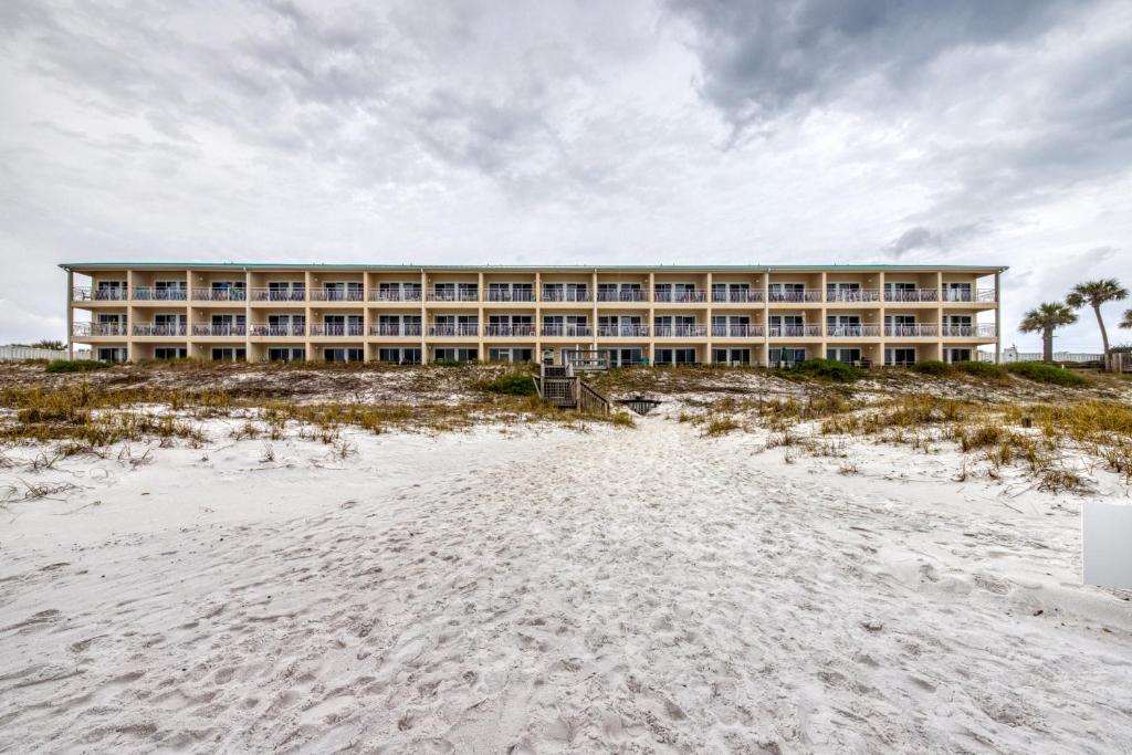 a hotel on the beach with a sandy beach in front of it at Crystal Sands Condominiums in Destin