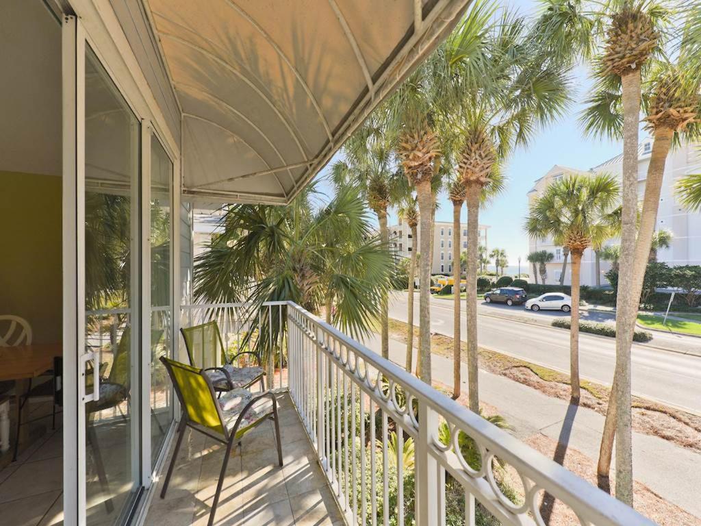 a porch with chairs and palm trees on a street at Nantucket Rainbow Cottages in Destin