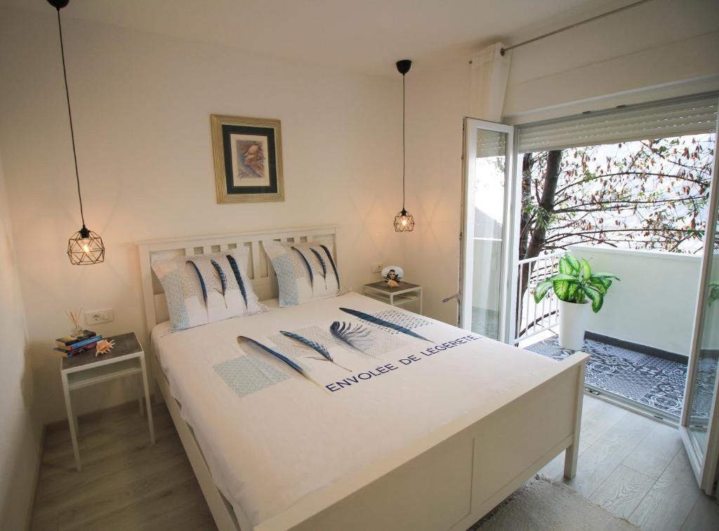 a bedroom with a white bed and a balcony at Viva Zadar in Zadar