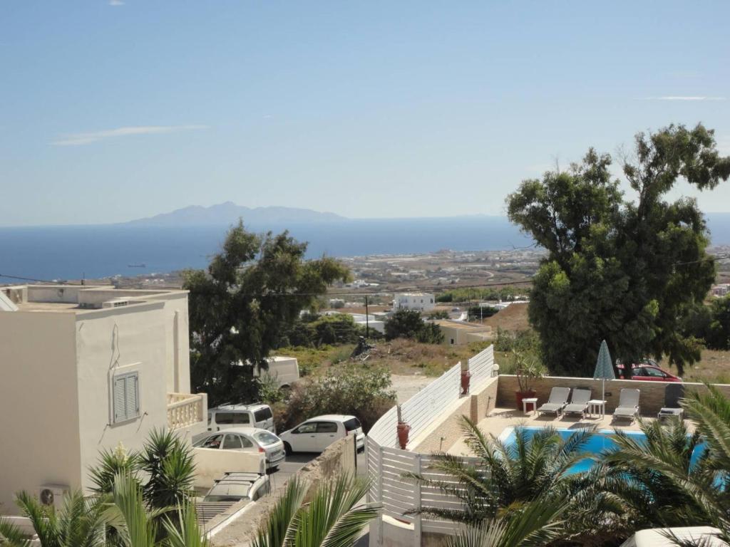 a view of a villa with a pool and cars at Triena Apartments in Fira