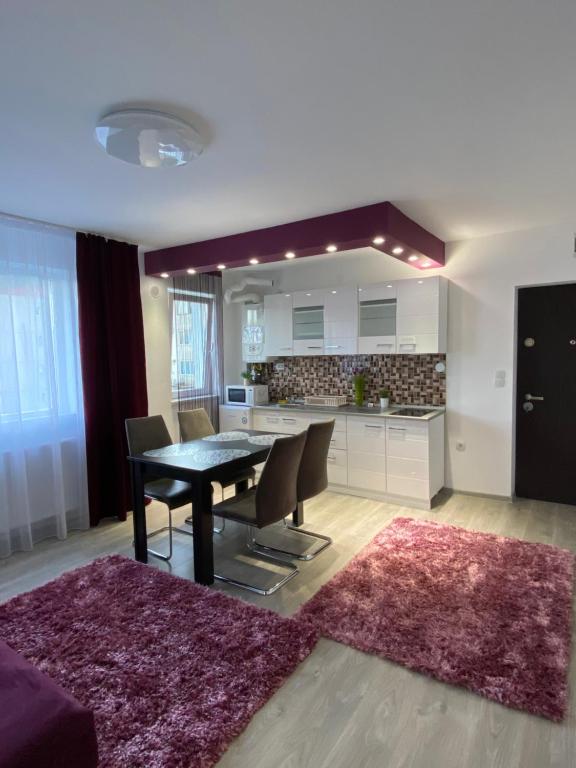 a kitchen and dining room with a table and chairs at 12 RESIDENCE APARTMENT in Cavnic