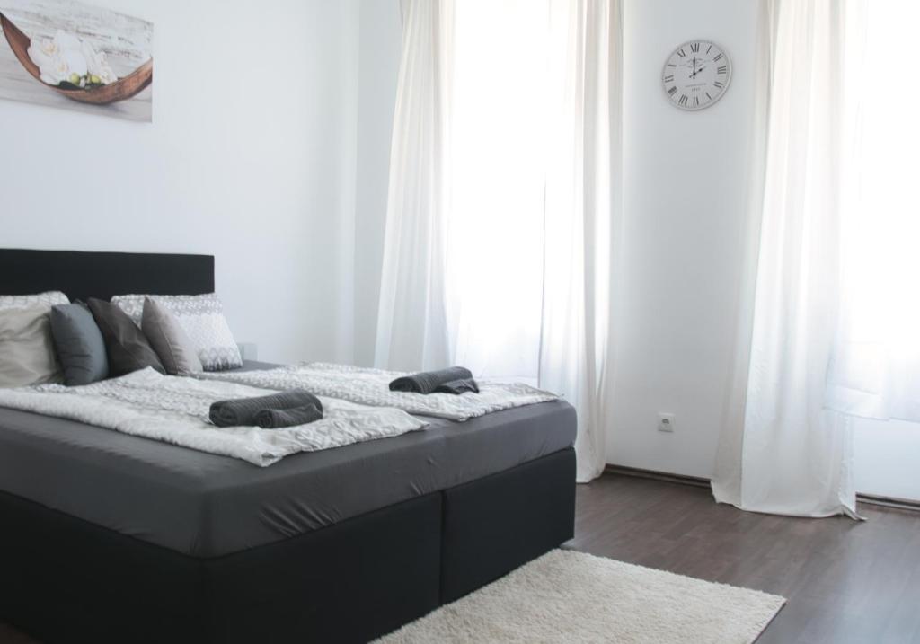 ein Schlafzimmer mit einem Bett mit einer Uhr an der Wand in der Unterkunft Rover Apartment in Wien