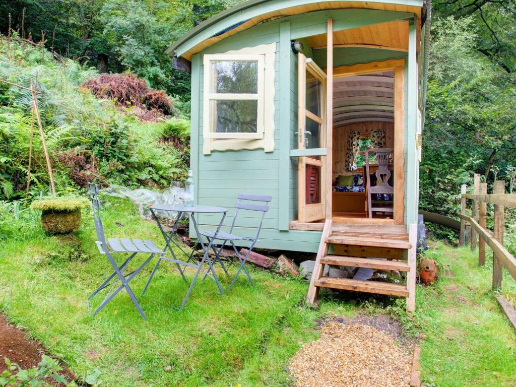 a blue tiny house with a table and chairs at Hill view Holiday Home with Garden in Taunton
