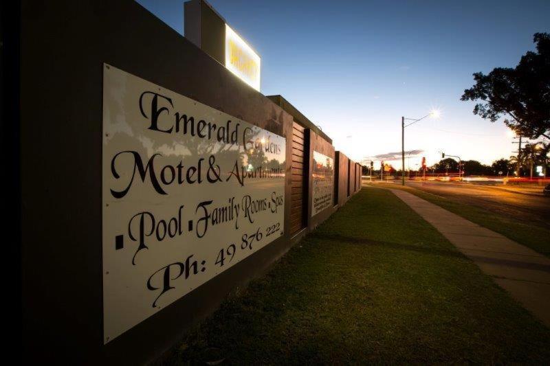 a sign on the side of a building at Emerald Gardens Motel & Apartments in Emerald