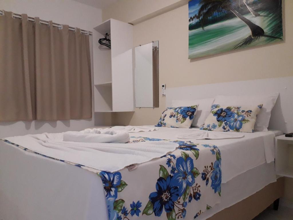 ein Schlafzimmer mit einem großen Bett mit blauen Blumen darauf in der Unterkunft Pousada Recanto do Sol e Mar in Porto De Galinhas