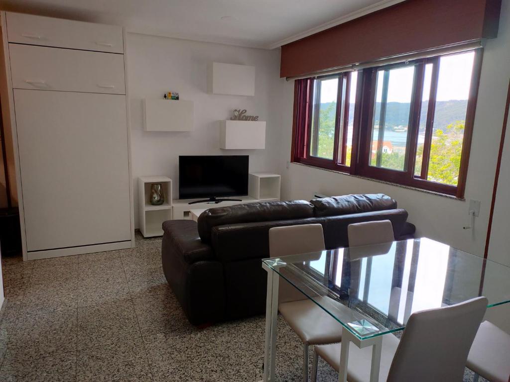 a living room with a couch and a television at Estudio tipo Loft en el centro de Mugardos in Ares