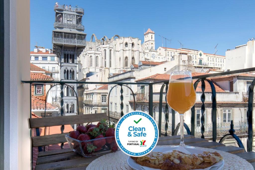 um copo de cerveja sentado numa mesa na varanda em Ando Living - Santa Justa 79 Townhouse em Lisboa