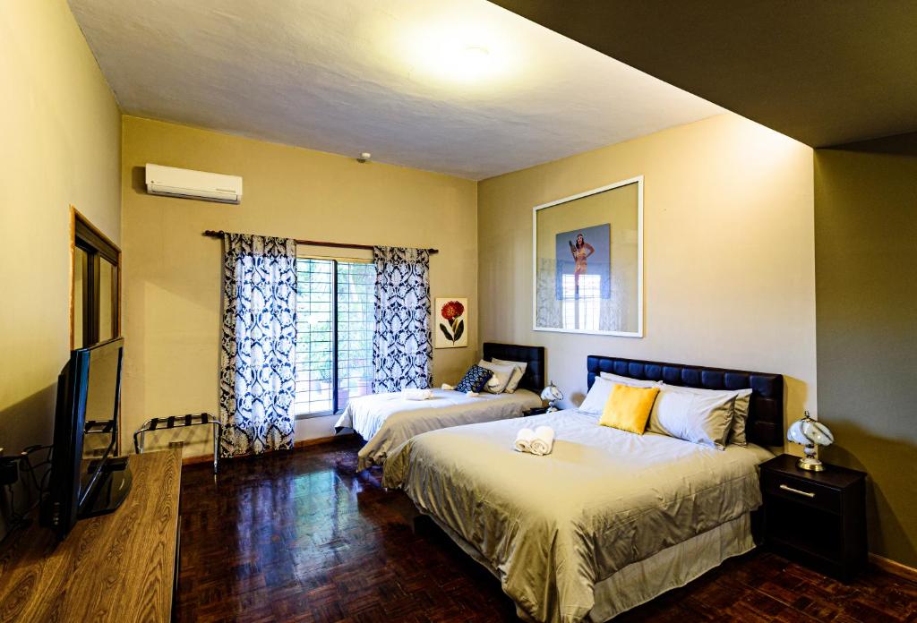 a bedroom with two beds and a flat screen tv at Ilioni Boutique Hotel in Guayaquil