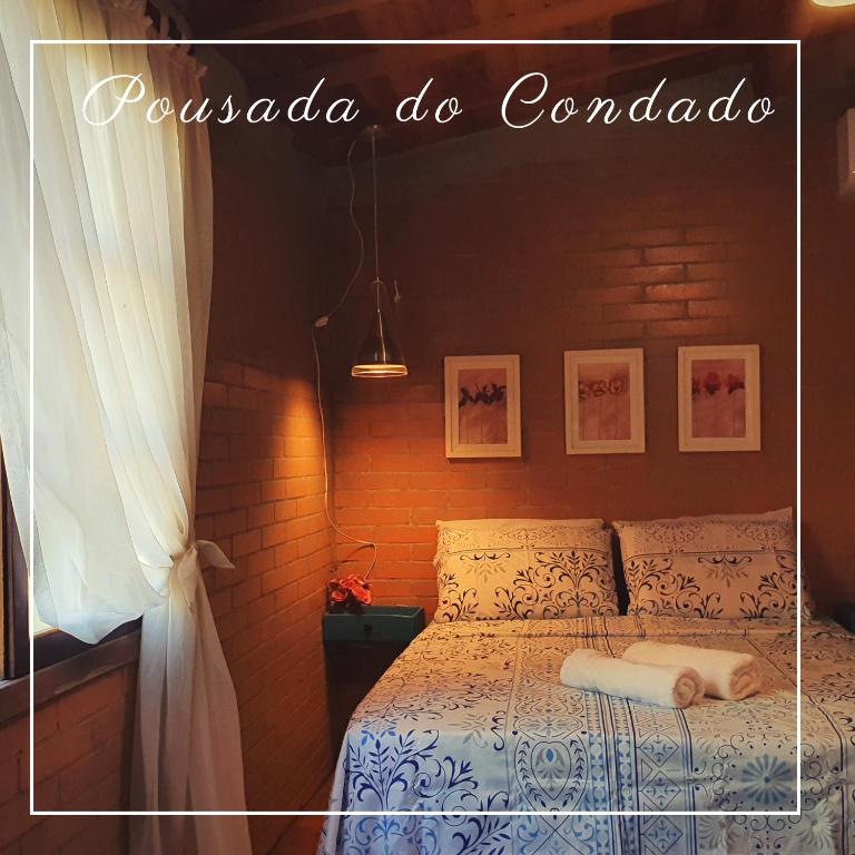 ein Schlafzimmer mit einem Bett mit einer weißen Bettdecke in der Unterkunft Pousada do Condado in Paraty