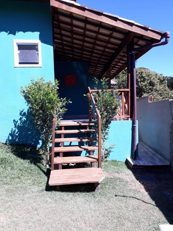una escalera de madera que conduce a un edificio con techo en Chalé e suite Manu en Ilhabela
