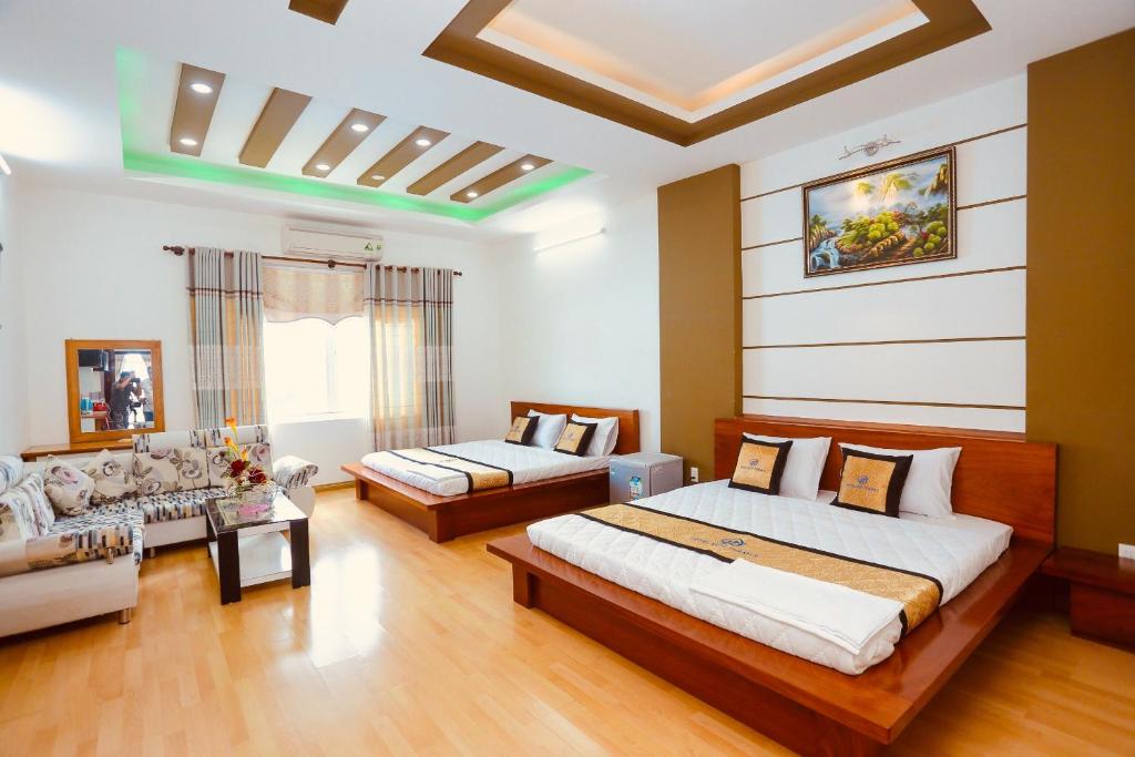 a large room with two beds and a couch at Hotel Đức Thành in Con Dao