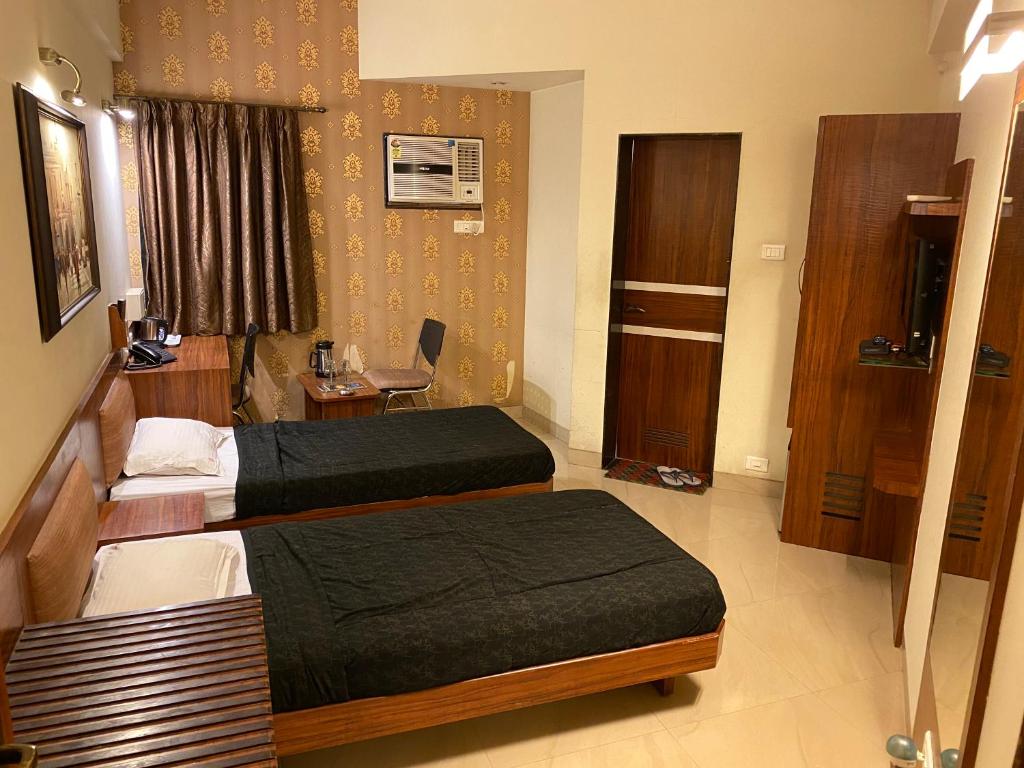 Postel nebo postele na pokoji v ubytování Panchavati Elite Inn