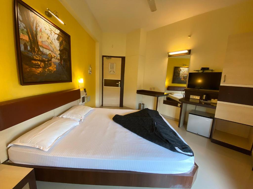 Postel nebo postele na pokoji v ubytování Panchavati Elite Inn