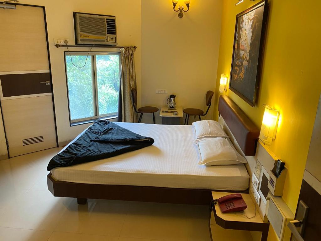 Postel nebo postele na pokoji v ubytování Panchavati Elite Inn