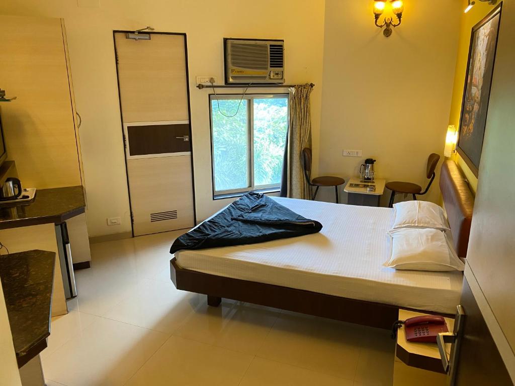 Postel nebo postele na pokoji v ubytování Panchavati Elite Inn