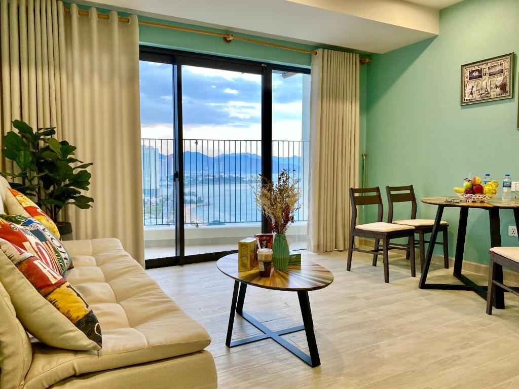 a living room with a couch and a table at Master's Gold Coast Apartments in Nha Trang