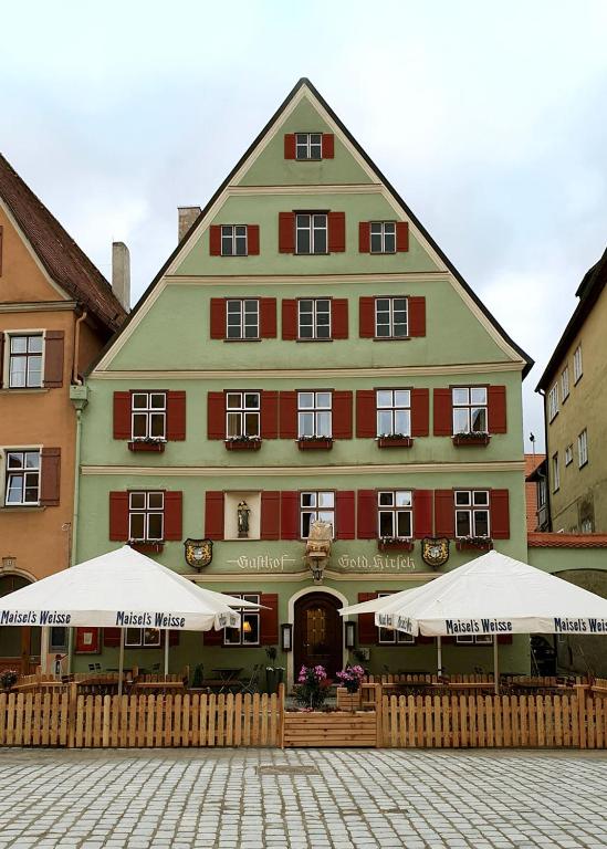 un grande edificio con due ombrelloni davanti di Goldner Hirsch a Dinkelsbühl