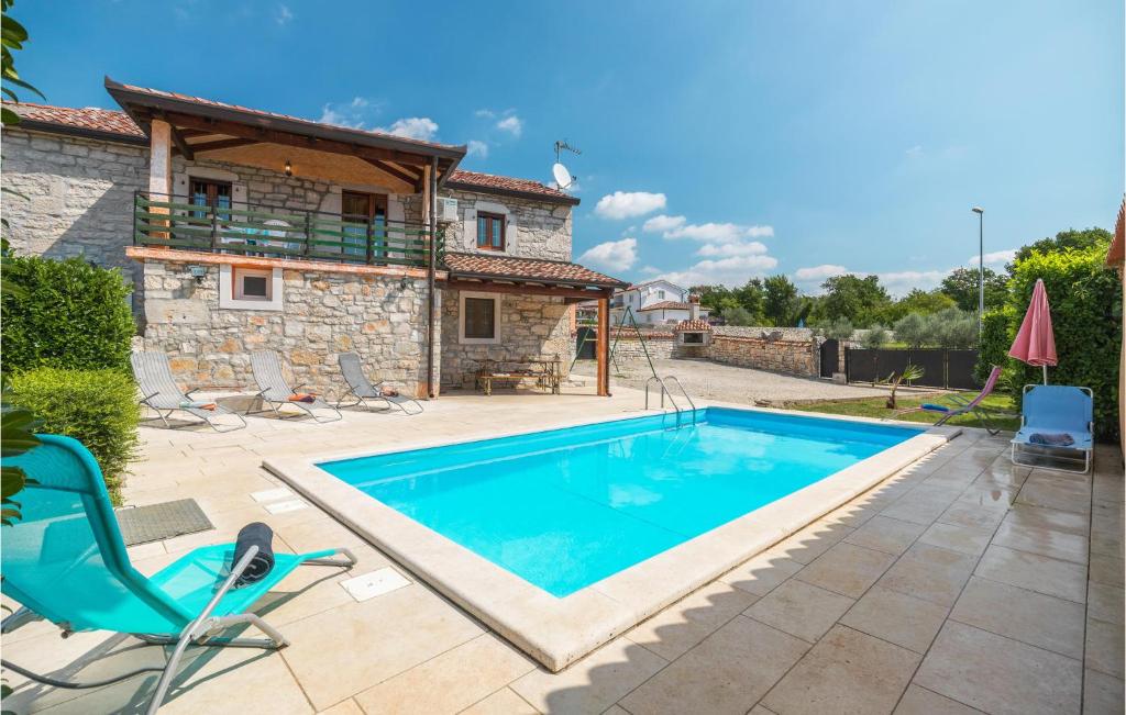 a villa with a swimming pool in front of a house at Lovely Home In Visnjan With Outdoor Swimming Pool in Višnjan