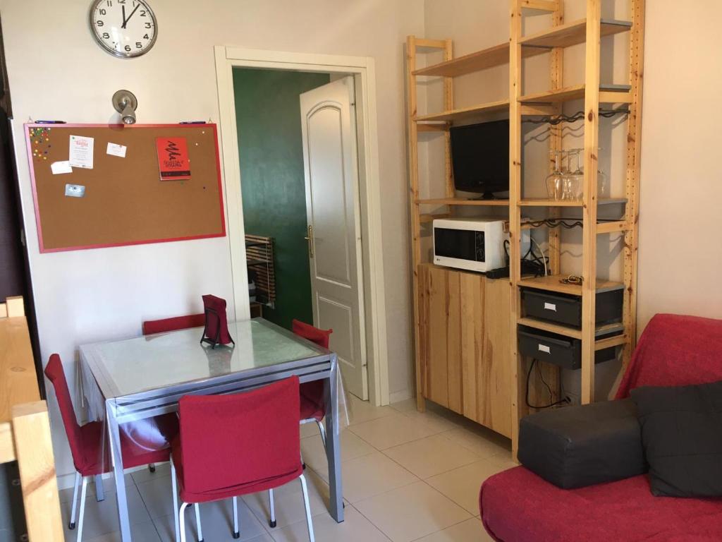 La cuisine est équipée d'une table, de chaises rouges et d'un réfrigérateur. dans l'établissement Pigafetta n 52, à Turin