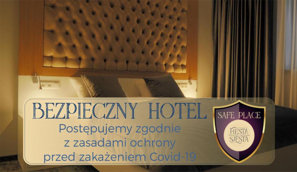 a sign for a hotel with a bed in a room at Hotel Sjesta in Nowa Sól