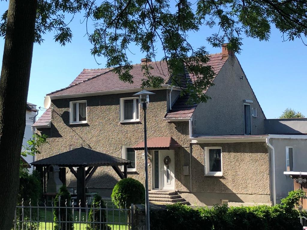 a large brick house with an umbrella at Pensjonat HANYSEK in Góra Świętej Anny