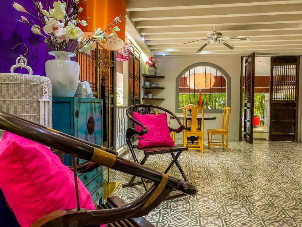a living room with pink chairs and a table at Sino House Phuket Hotel - SHA Plus in Phuket Town