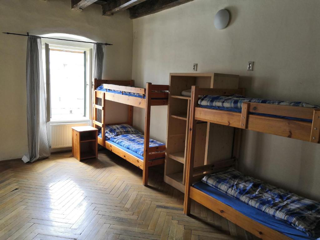 a room with three bunk beds and a window at Hostel Skautský dom in Banská Štiavnica