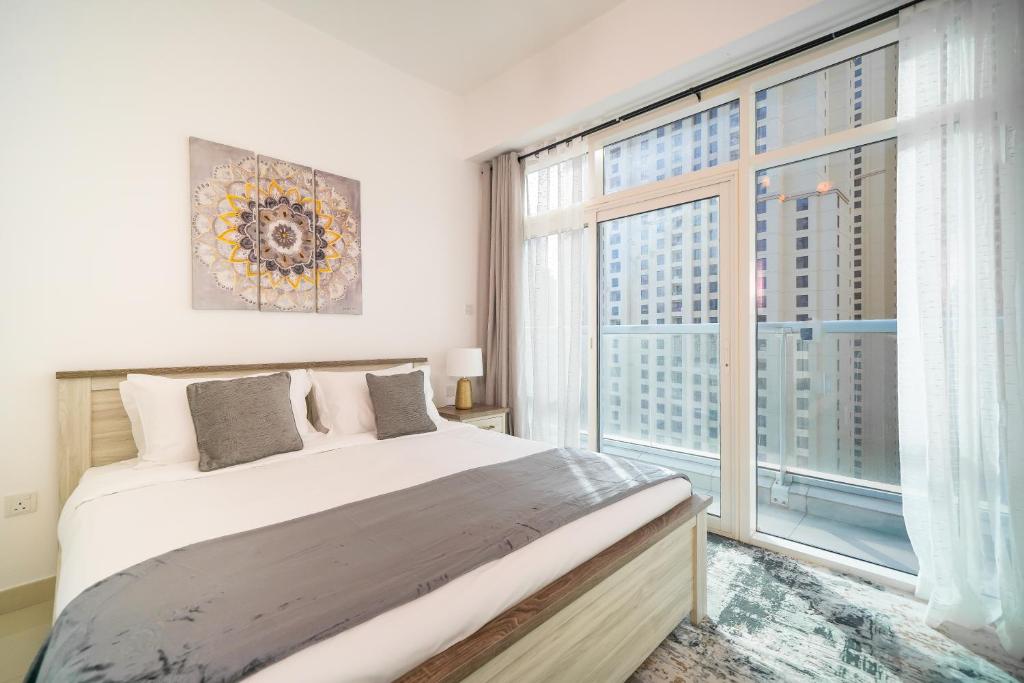 a bedroom with a bed and a large window at Luton Vacation Homes - Dubai Marina, Continental Tower in Dubai