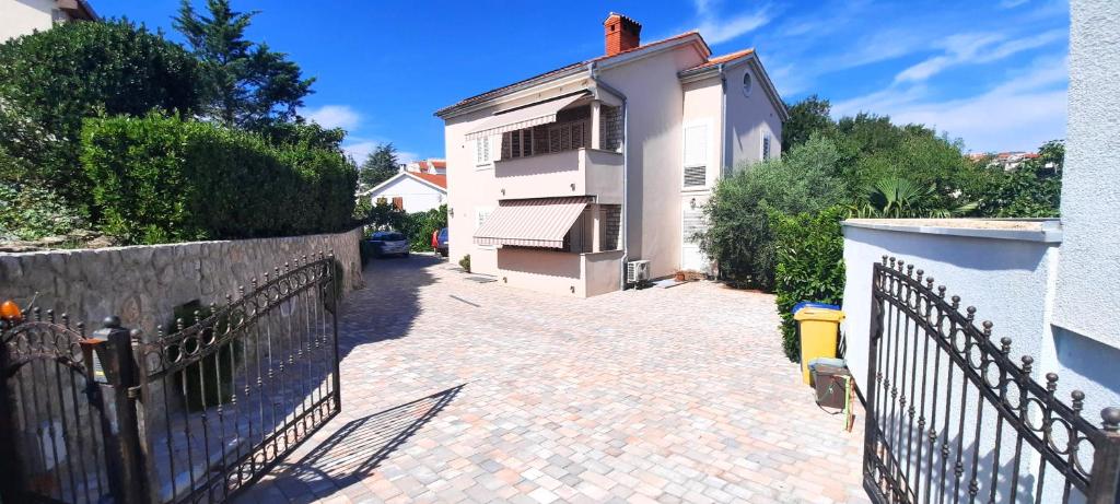 un vialetto in mattoni con una recinzione accanto a un edificio di Apartment Jan a Krk