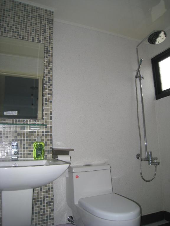 a bathroom with a toilet and a sink and a shower at Penghu 123 V-Stone in Magong