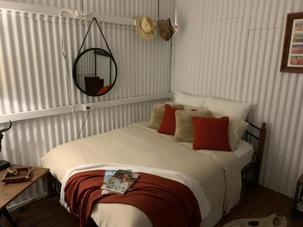 Schlafzimmer mit einem Bett und einem Spiegel an der Wand in der Unterkunft Evanston Station in Ilfracombe