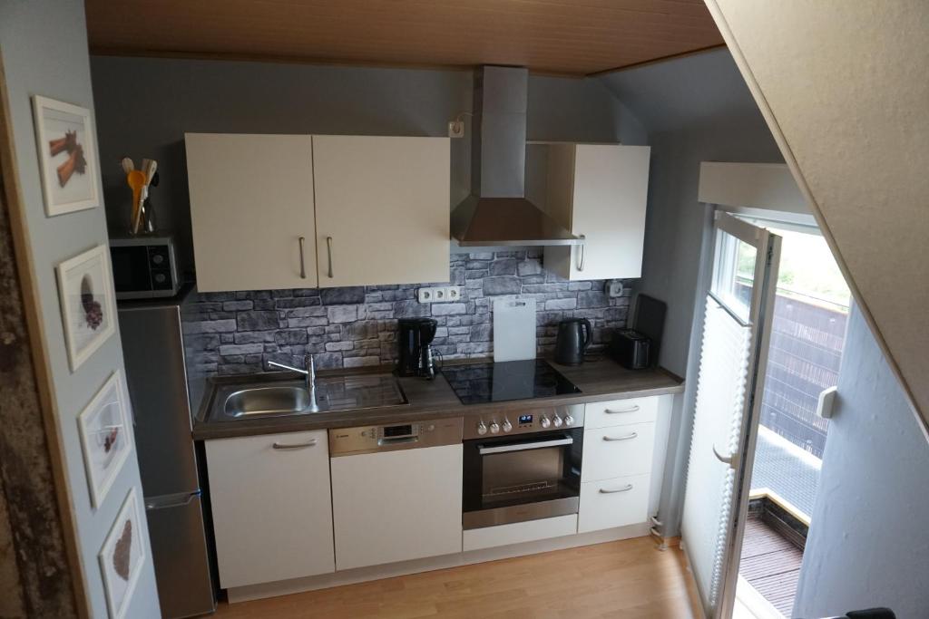 a small kitchen with white cabinets and a sink at Ferienwohnung Waldblick in Bad Wildungen