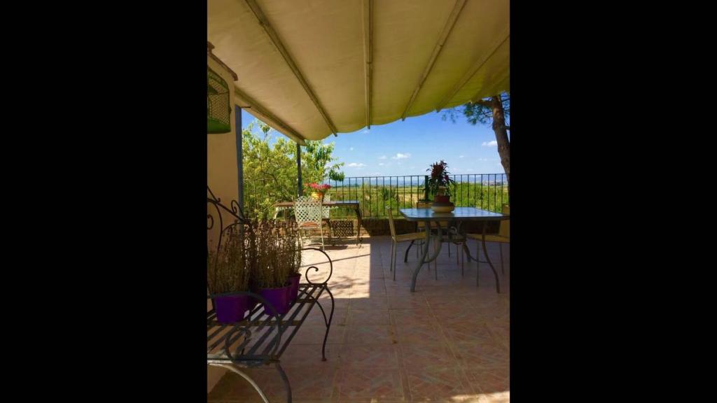eine Terrasse mit einem Tisch, Stühlen und einem Sonnenschirm in der Unterkunft Luxury Apartments Casa Burraia in Abbadia di Montepulciano
