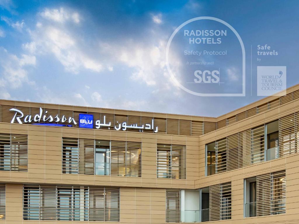 a building with a sign that reads radisson hotels sixty forbidden ses at Radisson Blu Hotel & Residence, Riyadh Diplomatic Quarter in Riyadh
