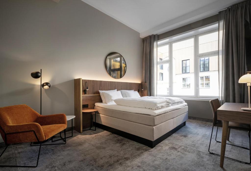 Habitación de hotel con cama y silla en Karl Johan Hotel en Oslo