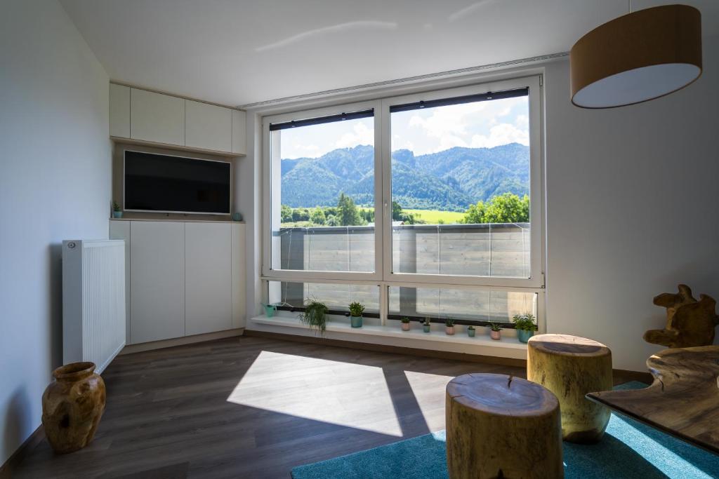 a living room with a large window with a view at Luxury Mountain View Apartment in Terchová