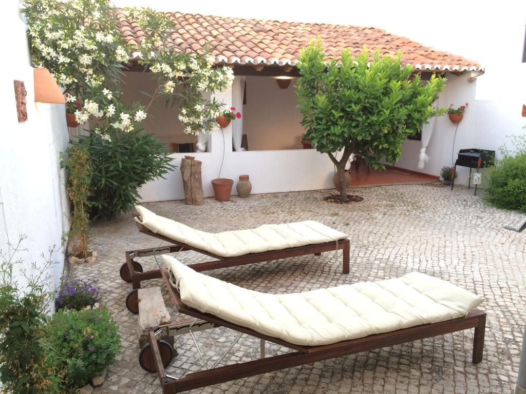 eine Terrasse mit Sofas und Bäumen sowie ein Gebäude in der Unterkunft Casa da Galega in Golegã