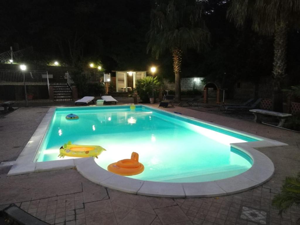 una piscina por la noche con un flotador en villa aurora, en Francavilla di Sicilia