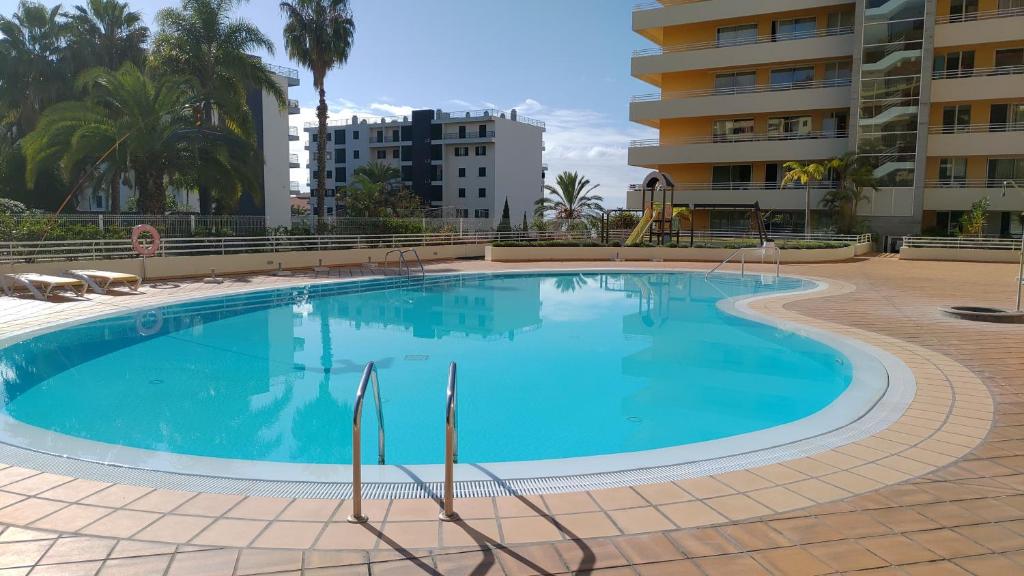 uma grande piscina azul num resort em Green Park Ajuda Apartment no Funchal