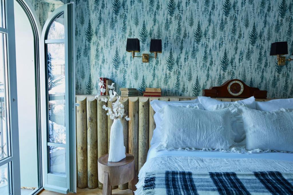 a bedroom with a bed and a tree wallpaper at Grand Hotel Soleil d'Or in Megève