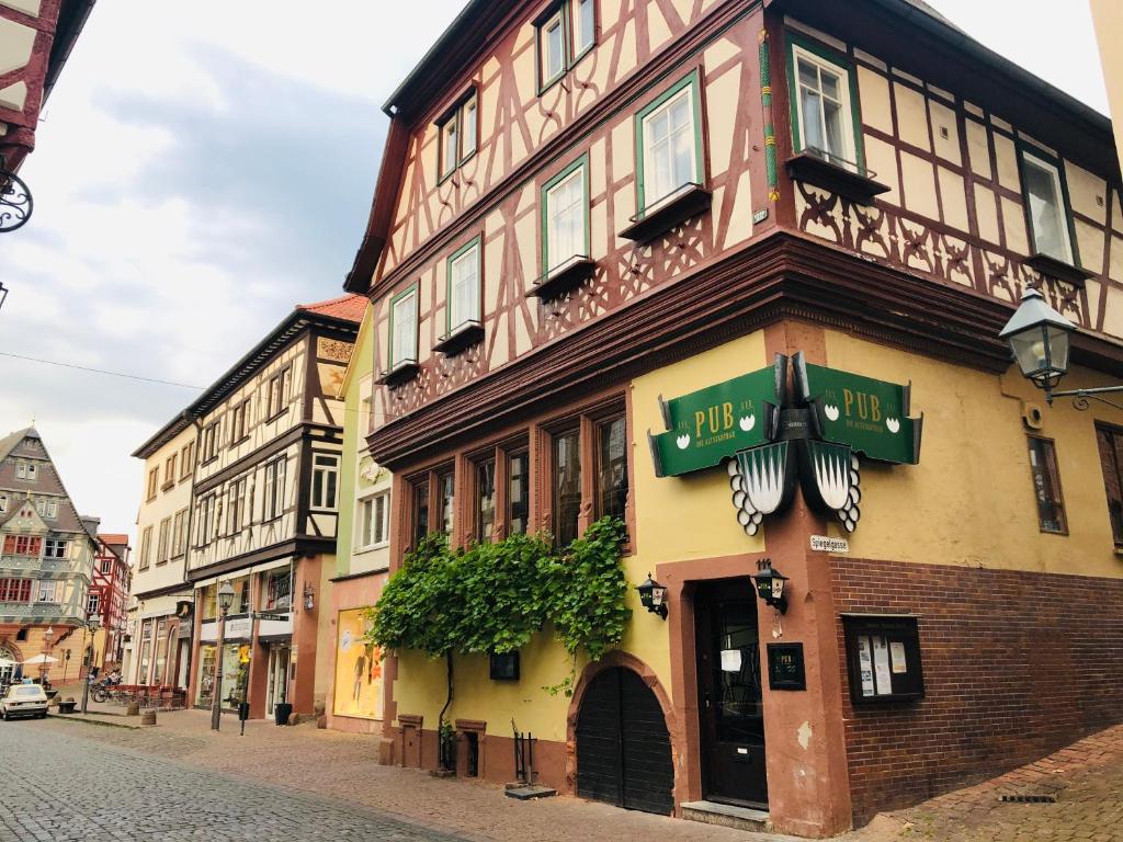 a building with a sign on it on a street at PUB 111 - Die Altstadt Unterkunft in Miltenberg